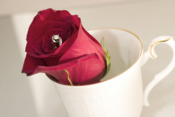 "Rosa rossa con anello di fidanzamento al centro, simbolo della proposta di matrimonio"