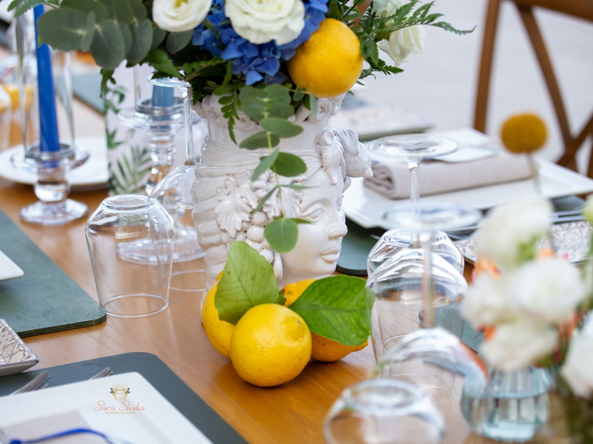 Matrimonio elegante Sicilia – Composizione di limoni e fiori bianchi come centrotavola e teste di moro