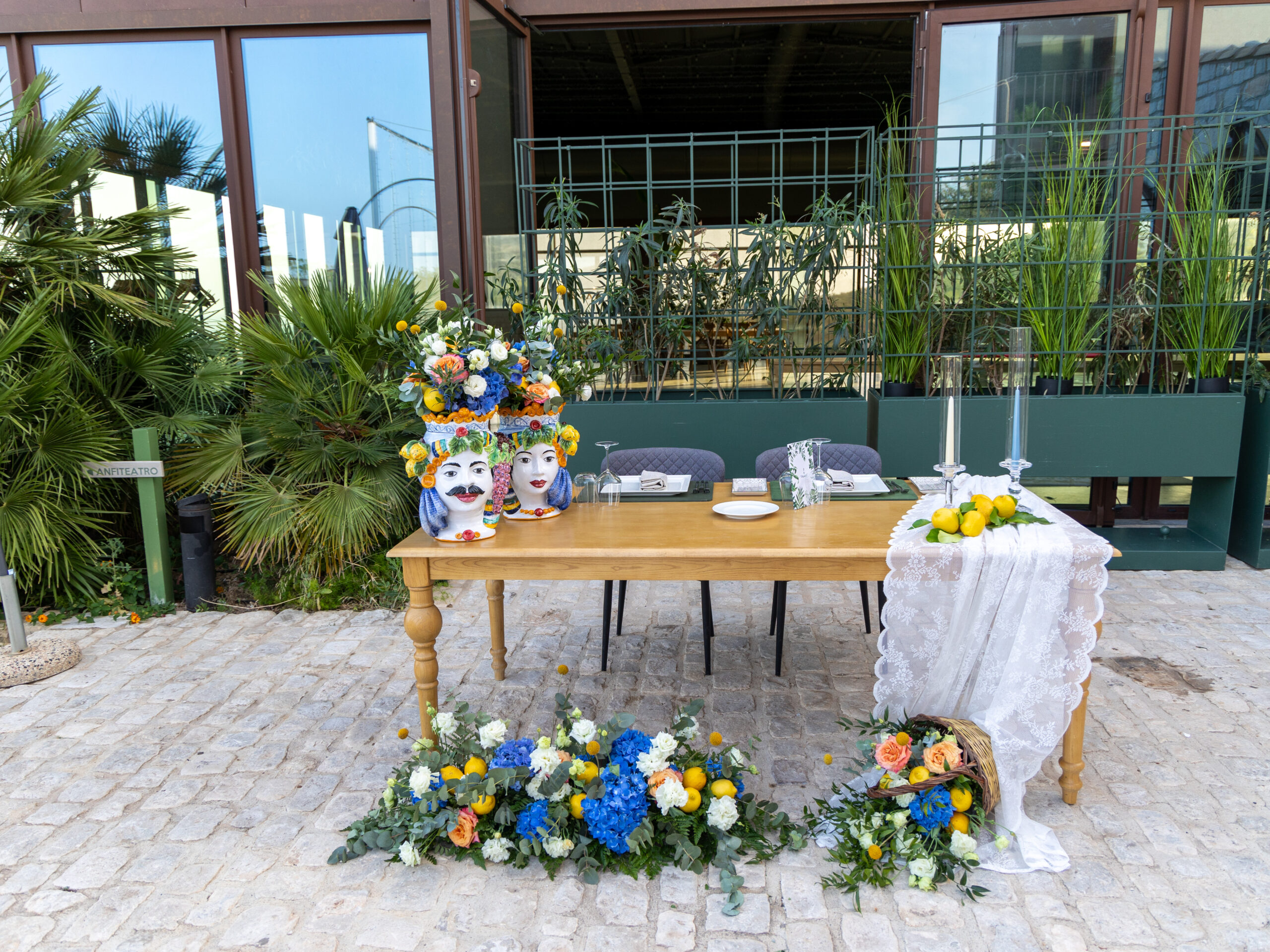 tavolo location dettagli siciliani con teste di moro e fiori bianchi